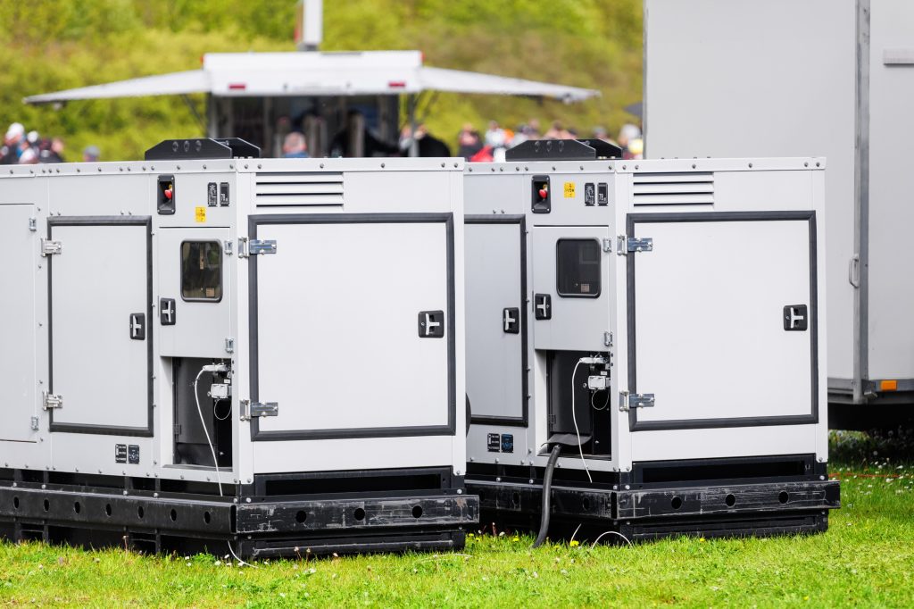 Set two large portable industrial power fuel generator green lawn at commercial event outdoors clear