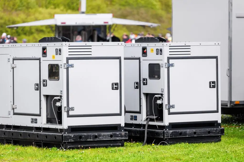 Set two large portable industrial power fuel generator green lawn at commercial event outdoors clear