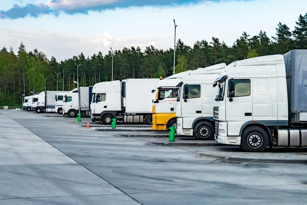 Trucks in a row with containers in the parking lot near forest , Logistic and Transport concept