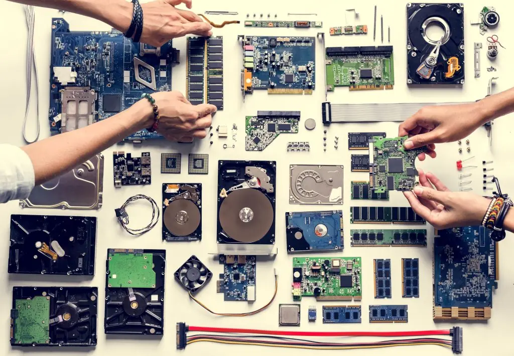 Aerial view of hands with computer electronics parts on white background
