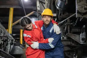 concerned-man-helping-injured-woman-in-factory-2026-03-20-00-52-34-utc
