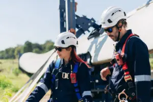 Professional wind turbine engineers preparing and inspecting equipment for installation and maintenance at a renewable energy site, teamwork, clean power, and sustainable technology.
